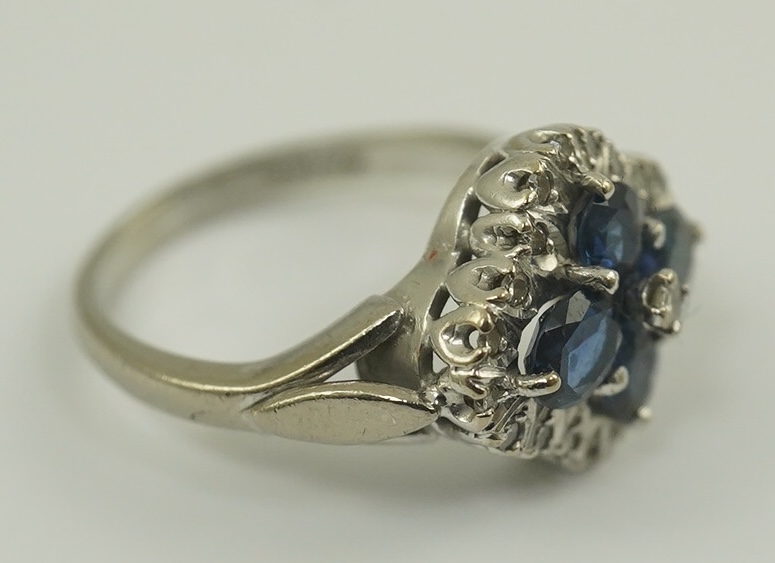 A modern 18ct white gold, sapphire and diamond cluster set ring